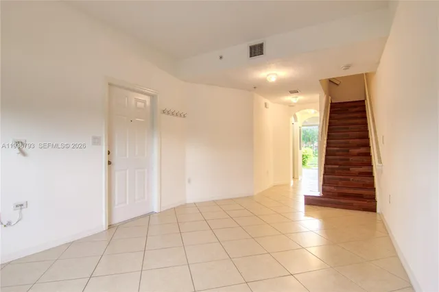 a view of a hallway with stairs and wooden floor