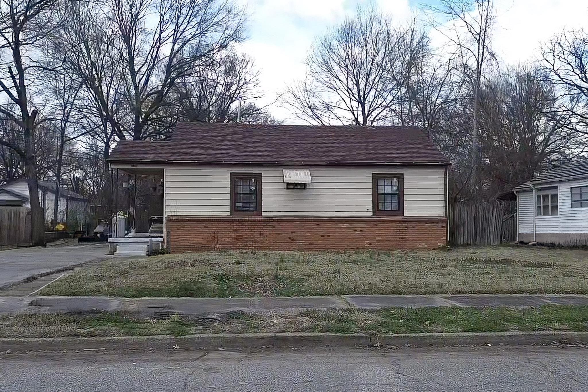 4942 Byron Road Memphis, TN 38122 - Photo 2 of 2 View of home's exterior with brick siding and a lawn