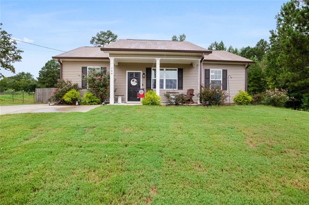 a view of a brick house with a big yard and large trees