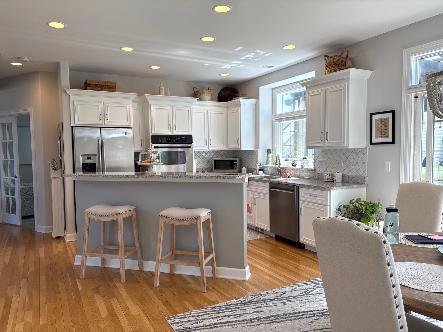 2212 Spartina Road Naperville, IL 60564 - Photo 5 of 17 a kitchen with stainless steel appliances granite countertop a refrigerator a stove top oven a sink dishwasher and white cabinets with wooden floor