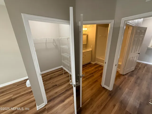 a view of a hallway with wooden floor and staircase