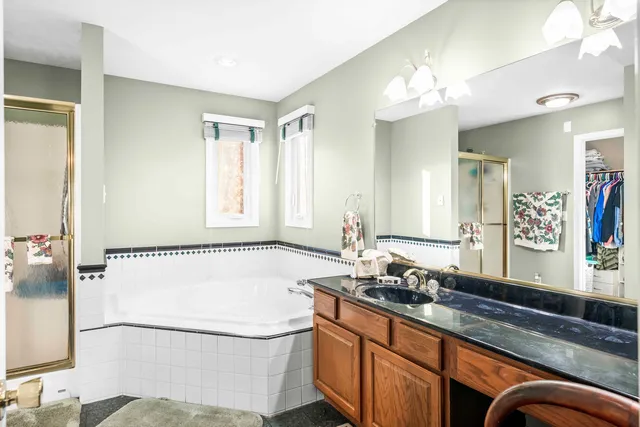 a bathroom with a tub sink and mirror