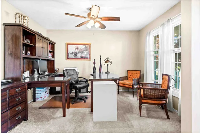 a view of a workspace with furniture and a window