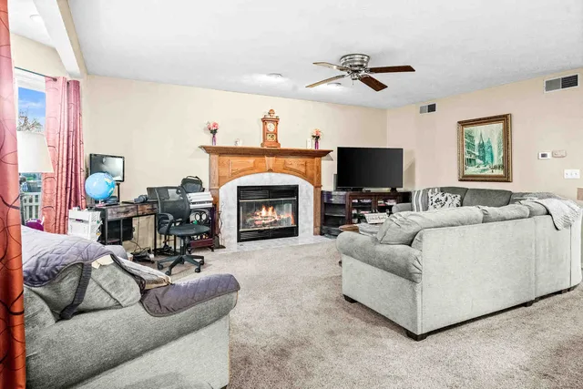 a living room with furniture a fireplace and a flat screen tv