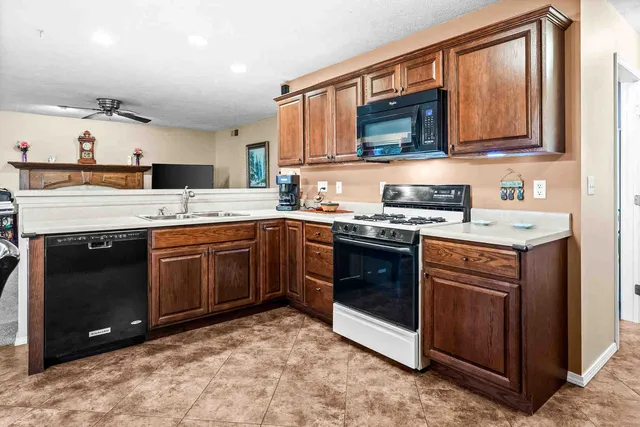 a kitchen with stainless steel appliances granite countertop a stove a sink and a microwave