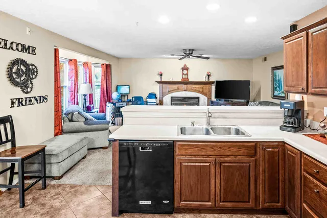 a kitchen with kitchen island granite countertop a sink and a stove top oven with wooden floor