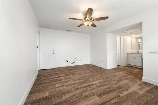 a view of a livingroom with wooden floor and a ceiling fan