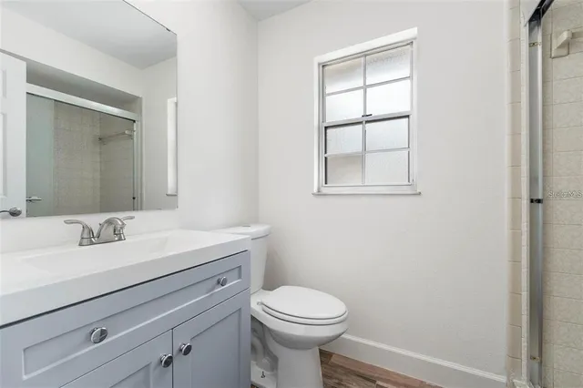 a bathroom with a toilet sink vanity and mirror