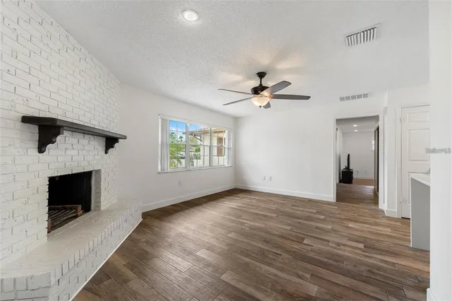 wooden floor in an empty room with a fireplace
