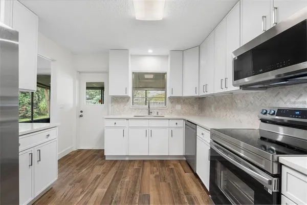 a kitchen with a sink stove and microwave