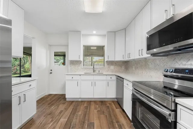 a kitchen with a sink stove and microwave