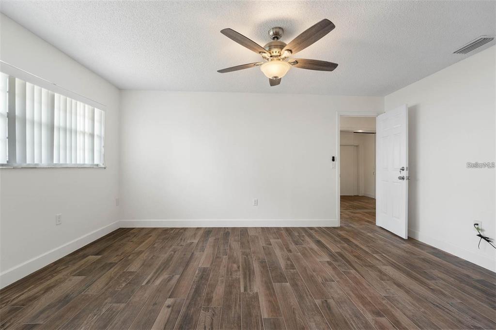 8323 Banyan Boulevard Orlando, FL 32819 - Photo 9 of 20 an empty room with wooden floor and windows