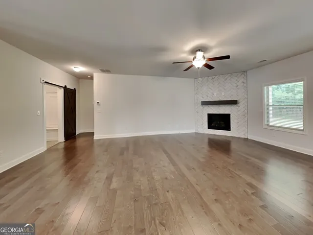 a view of an empty room with a window and a fireplace