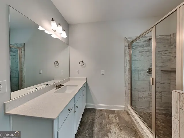 a bathroom with a double vanity sink a large mirror and shower