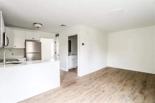 a kitchen with granite countertop a refrigerator and a sink