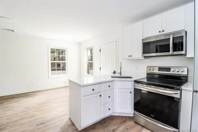 a kitchen with stainless steel appliances a stove microwave and cabinets