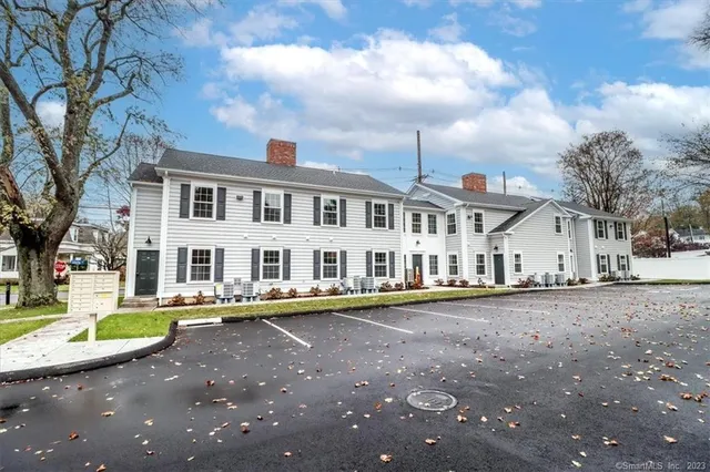 a front view of a house with a garden and trees