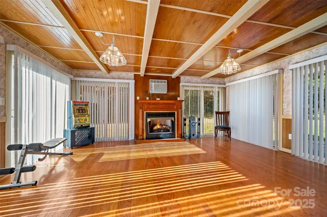 a view of a hall with wooden floor and a fireplace