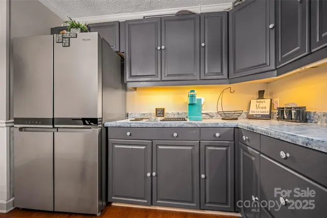 a kitchen with a sink a refrigerator and cabinets