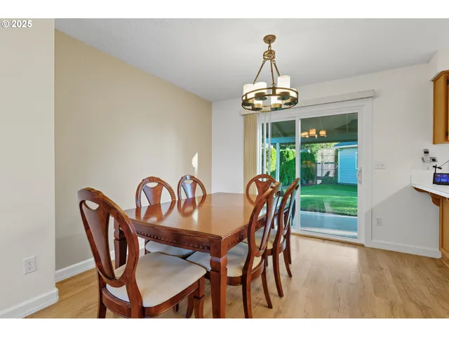 a dining room with furniture a chandelier and wooden floor