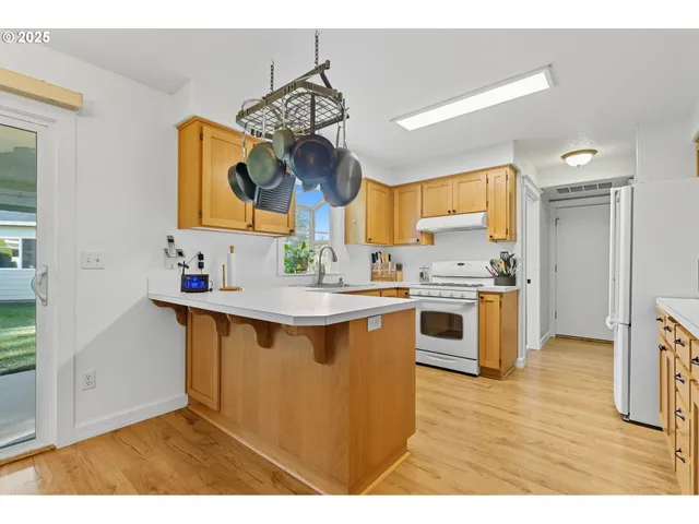 a kitchen with stainless steel appliances a sink cabinets and wooden floor