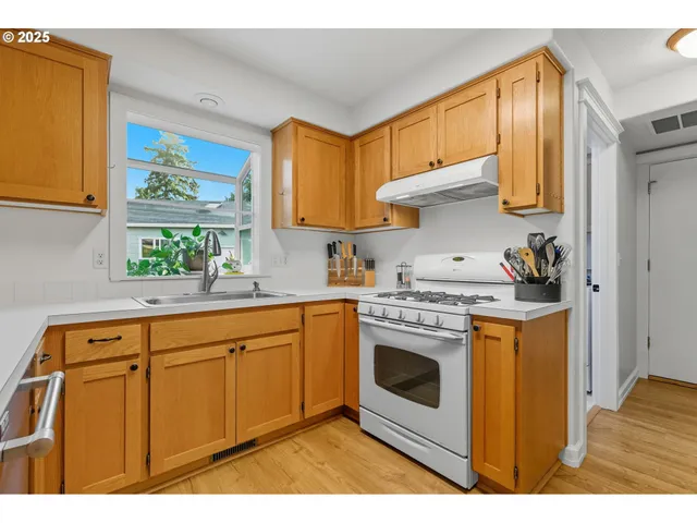 a kitchen with stainless steel appliances granite countertop a stove a sink and a microwave