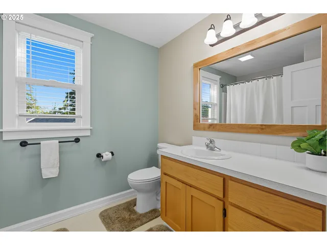 a bathroom with a granite countertop sink mirror vanity and toilet