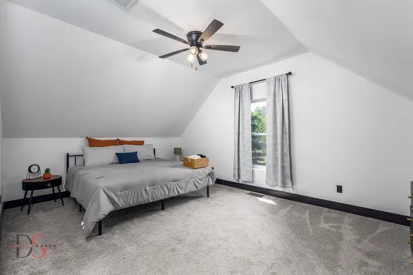 a bedroom with a bed and a ceiling fan