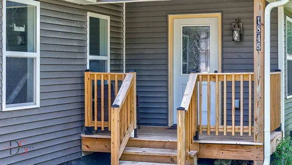 a view of front door and porch with wooden floor
