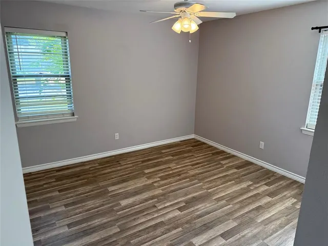 a view of a room with wooden floor and a window