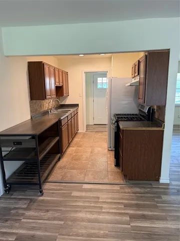 a kitchen with stainless steel appliances kitchen island granite countertop a stove and a refrigerator