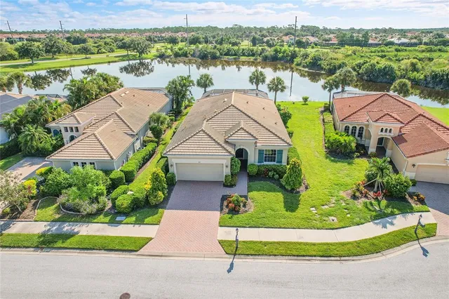 a aerial view of a house with a yard and lake view