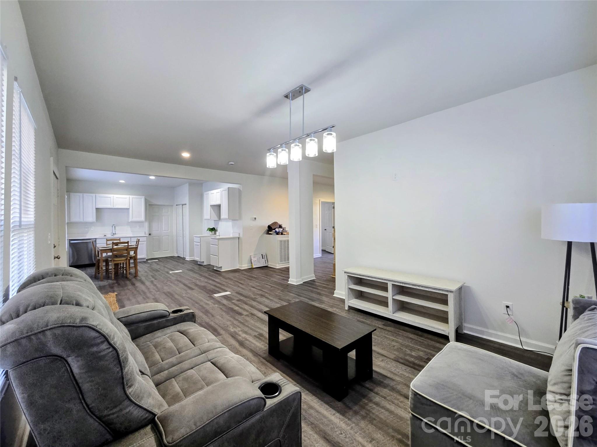 a living room with furniture and a chandelier