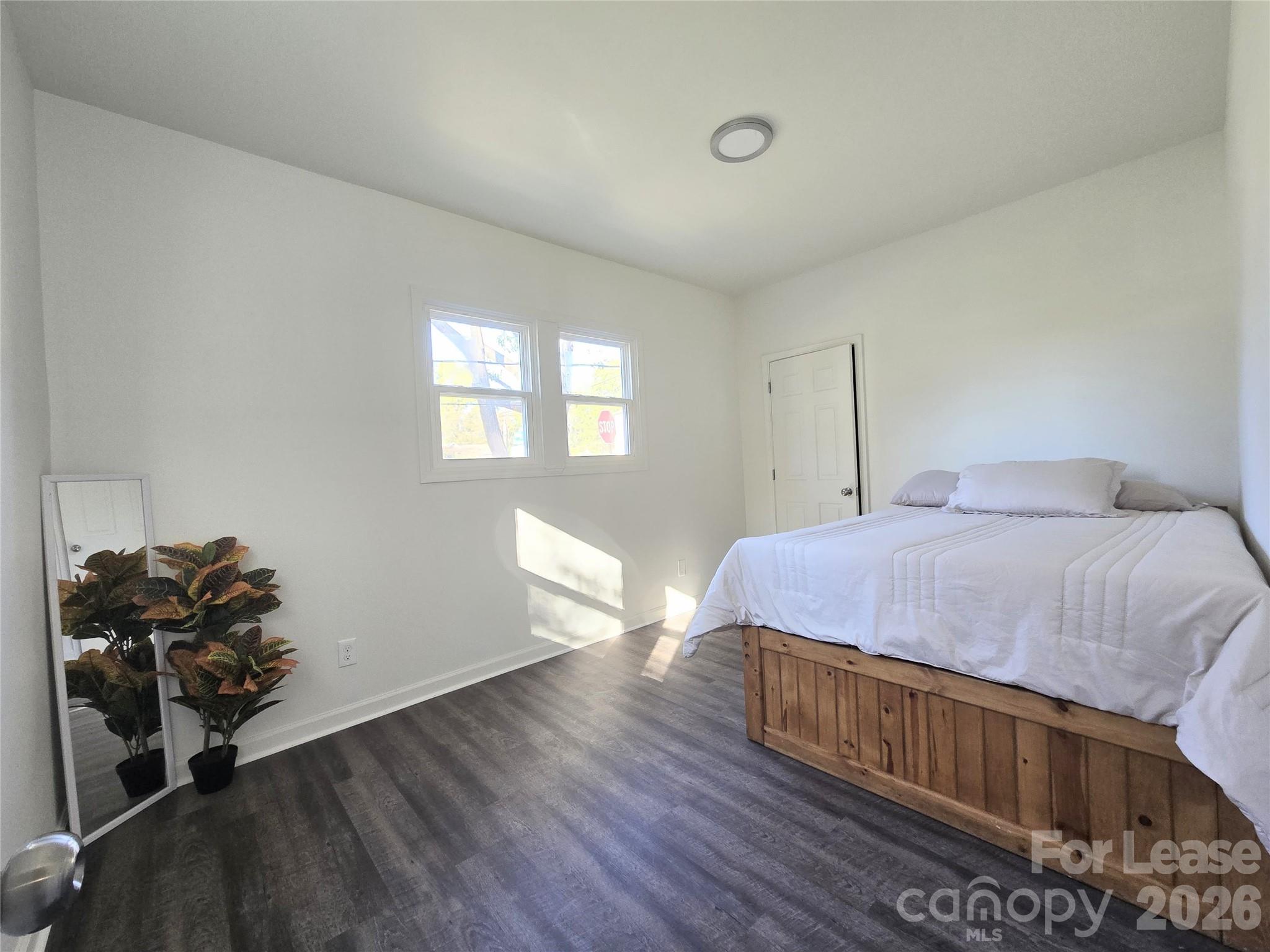 101 South Webb Street Gastonia, NC 28052 - Photo 32 of 40 a bedroom with a bed and wooden floor