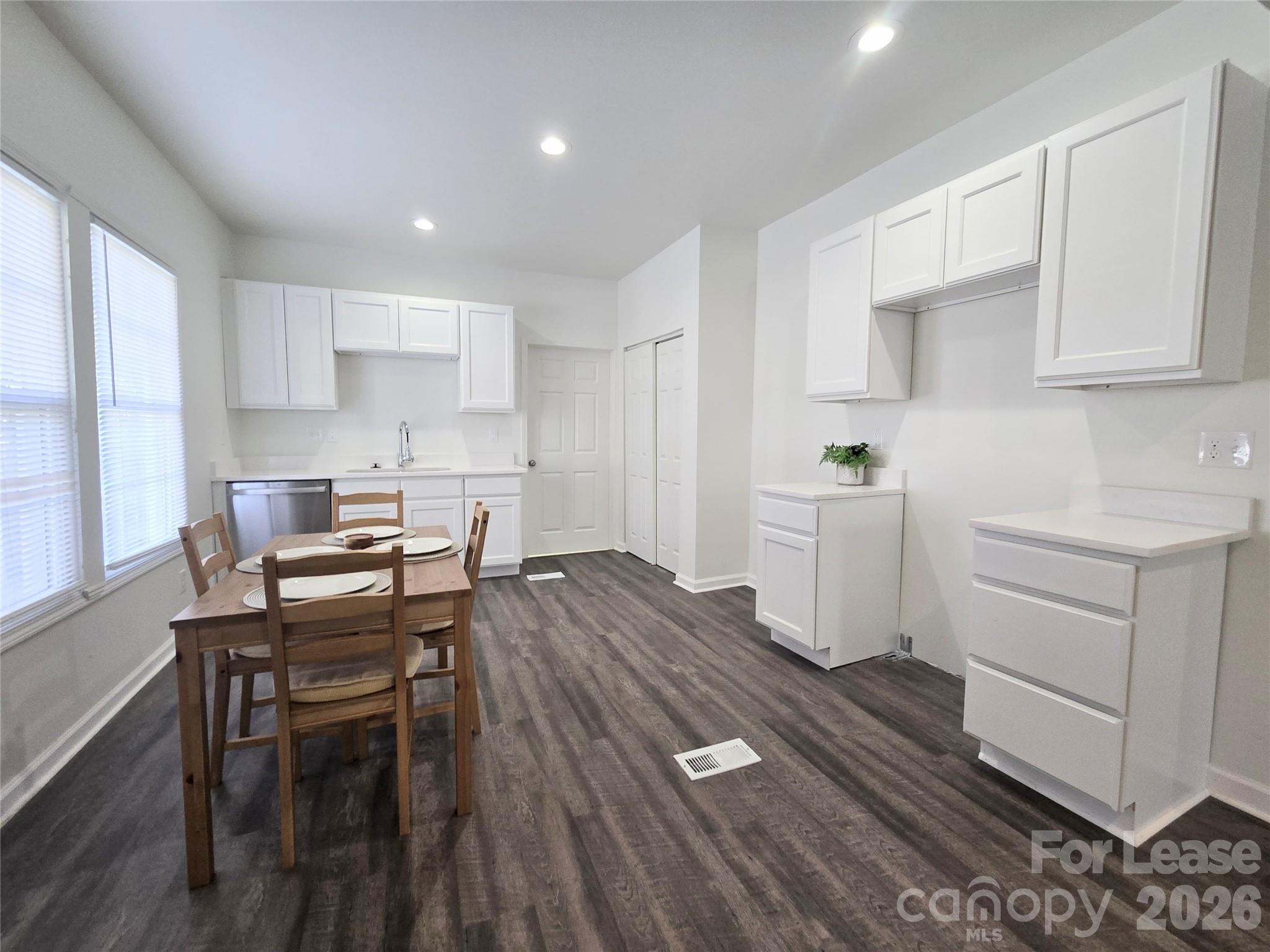 101 South Webb Street Gastonia, NC 28052 - Photo 5 of 40 a kitchen with a dining table chairs and white cabinets