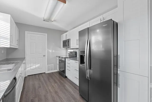 a view of a kitchen with wooden floor and a window