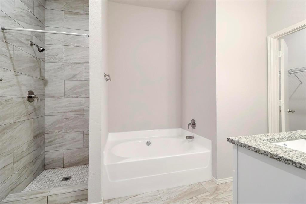 5528 Ridge View Drive Watauga, TX 76137 - Photo 11 of 16 Master Bathroom featuring a garden tub, vanity, a stall shower, and light marble finish flooring