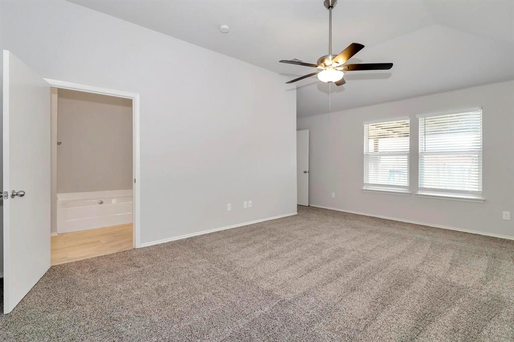 5528 Ridge View Drive Watauga, TX 76137 - Photo 10 of 16 Master bedroom with vaulted ceiling, light carpet, ceiling fan, and ensuite bath