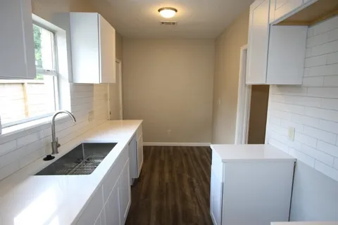 a kitchen with a sink and a stove top oven