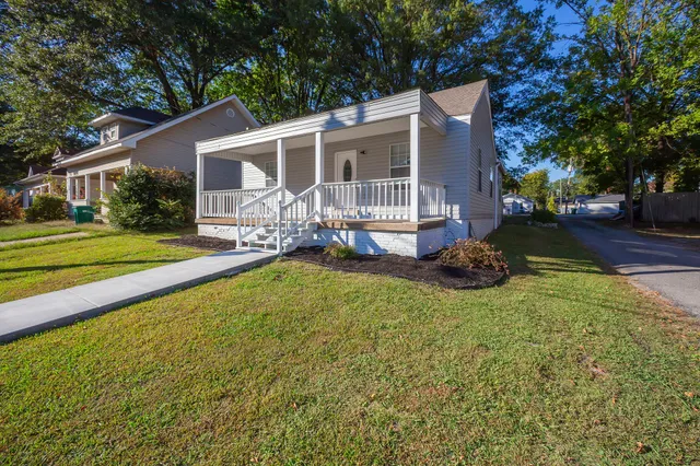 a view of a house with a yard patio and a small yard