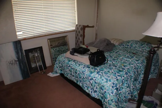 a bed sitting in a bedroom next to a window