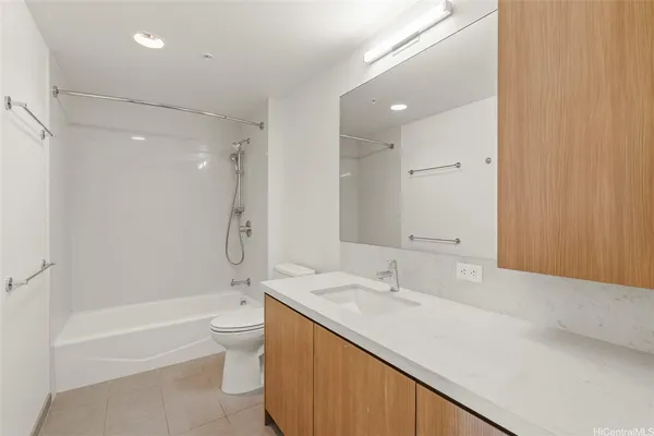 a bathroom with a granite countertop sink a toilet and shower
