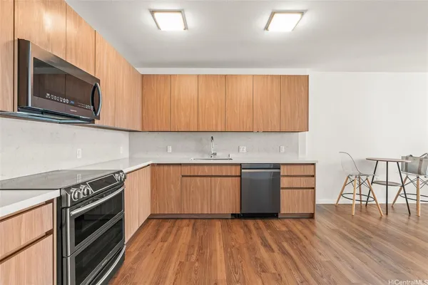 a kitchen with granite countertop wooden cabinets and a stove top oven