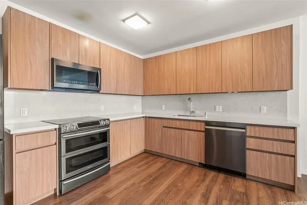a kitchen with granite countertop wooden cabinets and stainless steel appliances