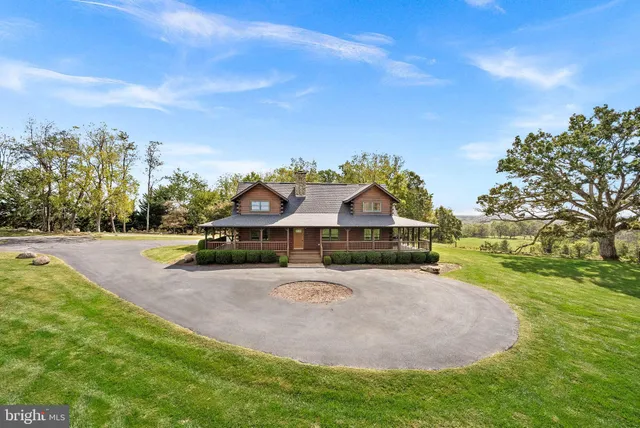 a front view of a house with a yard and trees