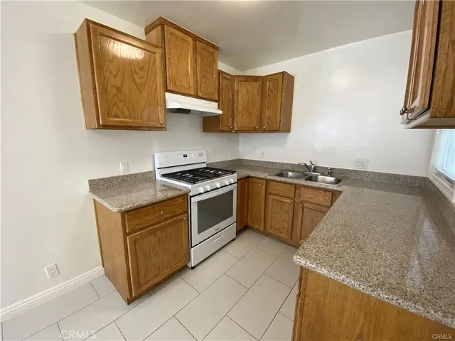 a kitchen with stainless steel appliances granite countertop a sink a stove and a microwave oven
