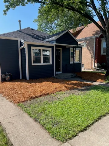 a front view of a house with a garden and yard