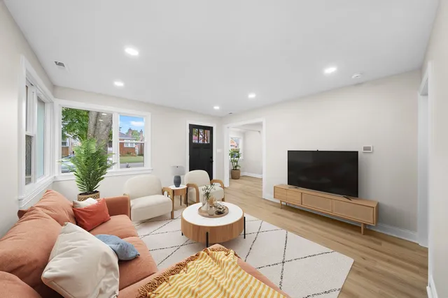 a living room with furniture a flat screen tv and a floor to ceiling window