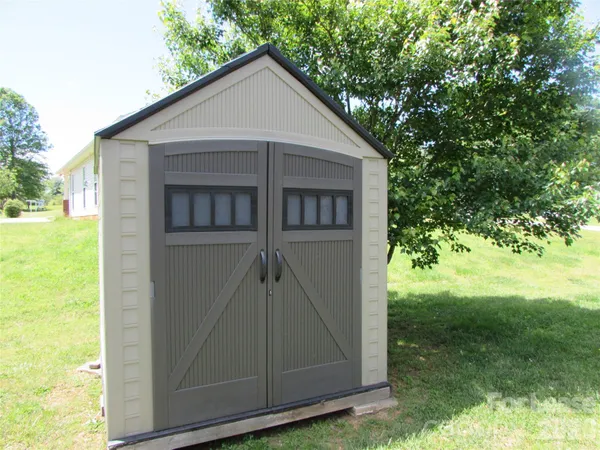 a view of a small house with backyard