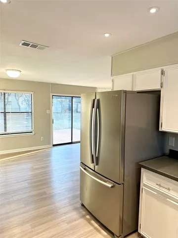 an empty room with wooden floor a ceiling fan and windows